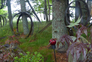 Giant metal orbs wrapped with twinkle lights hang in the garden