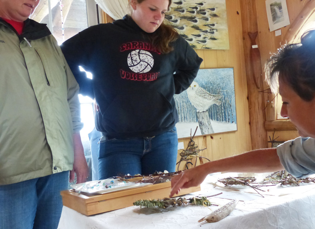 Barb Erickson chats with visitors about a project in progress at her studio/gallery; some of her fine art paintings are on the wall