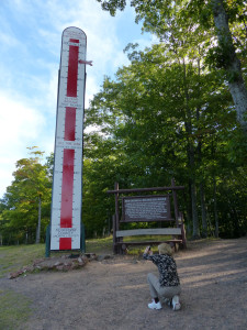 A tourist to the Keweenaw snaps the roadside snow stick in September